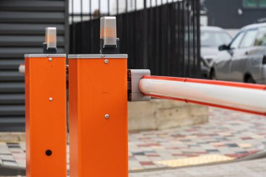 Otoparka giriş, parlak turuncu bir otomatik bariyer tarafından kontrol ediliyor. Girişteki güvenlik ve güvenliği arttırıyor..