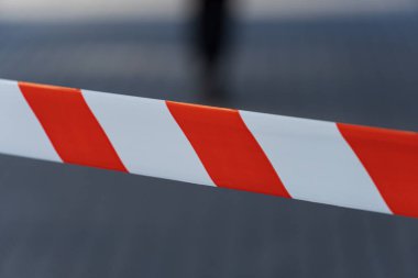 Aydınlık bir uyarı bandı yasak bölge boyunca uzanır, güneşli bir günde kentsel bir ortamda güvenlik kaygılarının sinyalini verir..