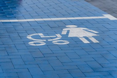 Bebek arabalı anneler için mavi işaretli bir park yeri görülebilir ve kalabalık bir yerdeki aileler için erişilebilirliği teşvik ediyor..