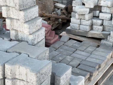 Tahta paletlerin üzerine yığılmış çeşitli beton bloklar gün ışığında inşaat alanına nakledilmeyi bekliyor..