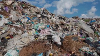 Bu klip, çöp birikiminin büyüklüğünü ve ekolojik etkisini gösteren, çeşitli atık tipleriyle dolu bir çöplüğü vurgular..