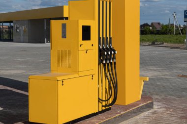 Benzin deposu açık alan ve temiz bir gökyüzünün altında korunan yüzeylerle çevrili bir benzin istasyonunda tek başına duruyor..