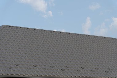 Çatı katına yeni fayanslar eklenerek, gün ışığında bir inşaat sahasındaki çatı işleminin görüntülenmesi sağlanıyor..