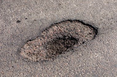 Yoğun bir otoyoldaki asfaltta büyük bir çatlak, sürücünün güvenliğini sağlamak için acil onarım gerektiren ciddi bir risk oluşturuyor..