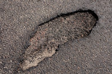 Otoyoldaki asfalttaki büyük bir çatlak araçlar için tehlike arz ediyor ve güvenliği sağlamak için acil onarım gerekiyor..