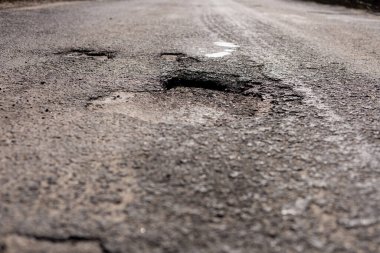 Asfalt otoyolunda büyük bir delik ve çatlaklar, sürücülerin güvenliğini sağlamak için acil onarım gerektiren önemli hasarlar içeriyor.