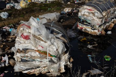 Bir çöp sahasındaki plastik atık dağları kirliliği açıkça gösteriyor ve ciddi ekolojik ve hijyen sorunlarını vurguluyor.
