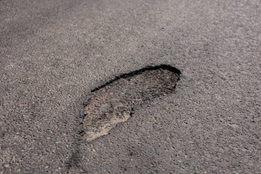 Bir şehir caddesinde göze çarpan bir çukur, açık havada kentsel altyapının korunmasında devam eden zorlukları gözler önüne seriyor.