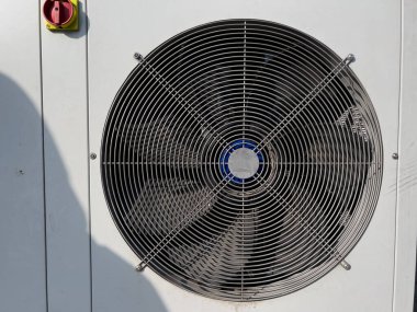 Serinletici fan şehir ortamında sıcak yaz günlerinde gerekli iklim kontrolünü sağlayan açık hava havalandırma ünitesinde sürekli olarak döner..