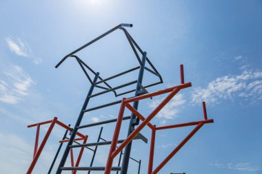 Paralel barlar açık hava spor salonunda dimdik durur, parlak bir güneş altında aktif yaşam tarzlarını ve güç eğitimini desteklerler..