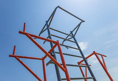 Parlak renkli spor salonu yapısı mavi gökyüzüne karşı dimdik ayakta duruyor fitness meraklıları için çeşitli spor faaliyetlerini destekliyor..