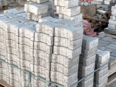 Birçok beton blok, çeşitli inşaat faaliyetlerinde kullanılmak üzere bir inşaat sahasında düzgünce düzenlenmiştir..