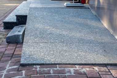 Manzara, yüzey tasarımında bir kontrastlık yaratan, dokulu tuğla kaldırımın yanında pürüzsüz bir gri taş kaldırım içeriyor..