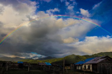 Dağda gökkuşağı ve bulutlar