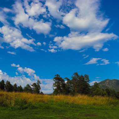 Mavi gökyüzü ve bulutlu dağ manzarası