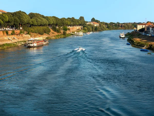 stock image Wide view from Pavia's Ponte Coperto of the Ticino River with a motor boat leaving a foamy wake behind it, tourist boats and small boats on a sunny afternoon