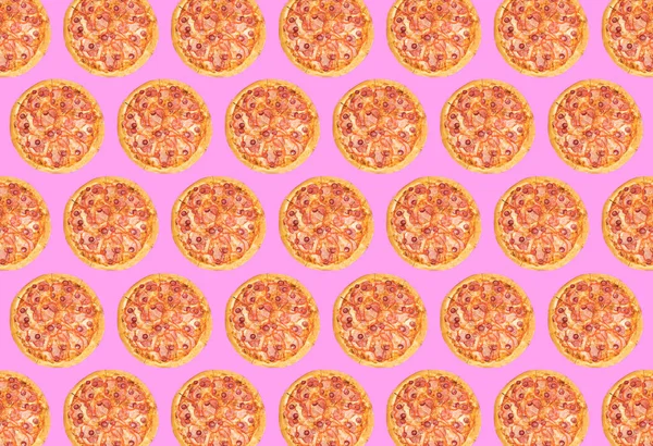 Pembe arka planda bütün bir pizzanın modaya uygun renkli tekrarlama kalıbı. Yüksek kalite fotoğraf