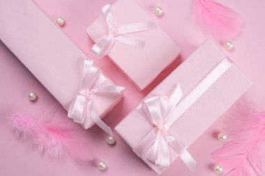  Pembe fiyonklu pembe hediye kutuları tüylerle süslenmiş, üst görünüm, bir kızın doğum gününü kutlama konsepti, parti, pembe renkli yıldönümü, ya da satış ve alışveriş, ya da yeni doğmuş bir kız.. 
