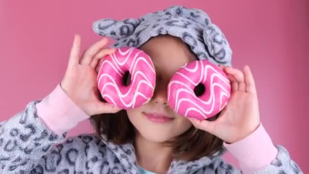 Kigurumi Giymiş Bir Kız Pembe Arka Planda Gözleri Yerine Donutlu — Stok video