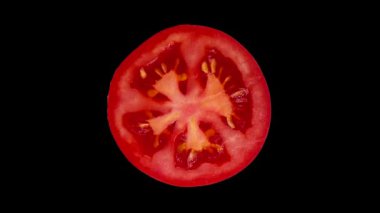 Olgun domatesin yarısını siyah arka planda döndüren modern yemek animasyonu. Yüksek kalite 4k görüntü