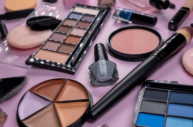 Dekoratif kozmetik ürünleri, kızartıcı, gizleyici, toz, gölge, tırnak cilası, makyaj fırçası, kirpik fırçası veya pembe arka planda kaş fırçası, kozmetik ürünleri, güzellik salonu veya moda endüstrisi kavramı. 