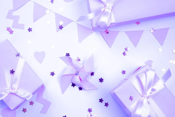 Pembe süslemeleri ve hediye kutuları olan mor bir arka plan, dekoratif, narin, arka plan. Parti konsepti ya da mor renkli doğum günü partisi ya da yeni doğmuş bir kız bebek. Yüksek kalite 4k görüntü