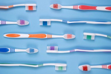 mavi arkaplan görünümünde farklı renkte diş fırçaları. 