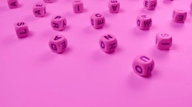 Yeni doğmuş bir kız çocuğu, okul eğitimi ya da öz eğitim kavramı, pembe arka planda rastgele harflerle sözcükleri döndürür ya da engeller 