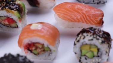 Farklı suşi türleri, ton balığı ve somon ile rulo, pirinç havyarı ve beyaz arka planda balık yüksek kaliteli 4K görüntü