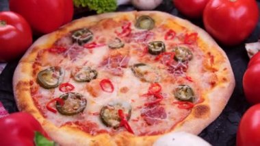 Siyah arka planda sebze arkaplanı olan pepperoni pizza. Yüksek kalite 4k görüntü