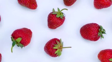 Beyaz arka planda olgun çilekler dönüyor, modaya uygun, parlak, yaz arkaplanı. Yüksek kalite 4k görüntü