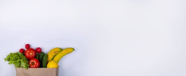 white background with space to insert text with a paper bag for products with vegetables. High quality photo