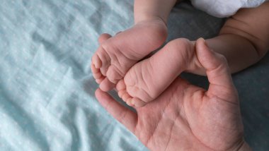 Female hands hold the baby's legs close-up. High quality 4k footage