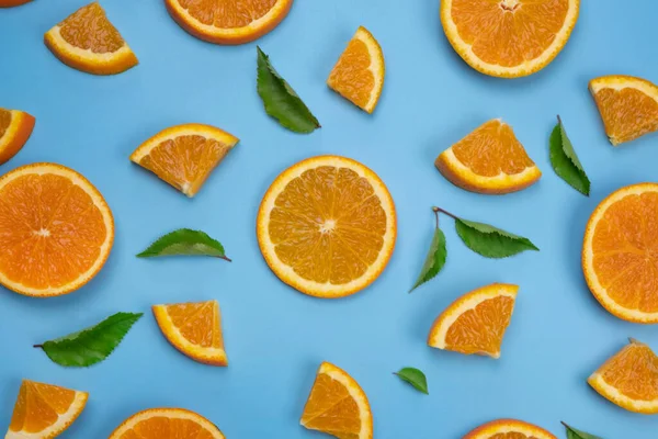background with slides of orange and leaves on a blue background, trendy summer, fruity background.