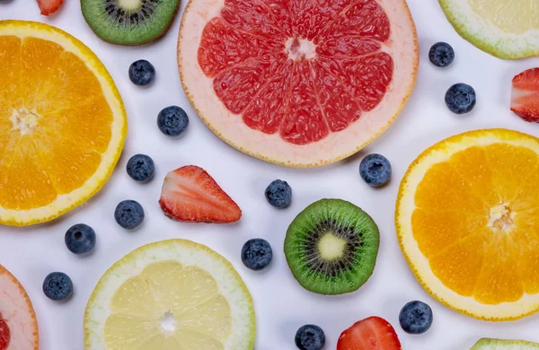 Beyaz arka planda yabanmersini, çilek, limon, portakal, greyfurt ve kivi dilimleri. Sağlıklı beslenme kavramı. Yaz aylarında meyveler, gıda tasarımı. 