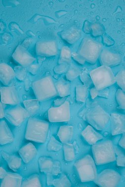 Buz küpleri ve su damlalarıyla dönen mavi arka plan. Yüksek kalite 4k görüntü