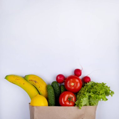 white background with space to insert text with a paper bag for products with vegetables. High quality photo
