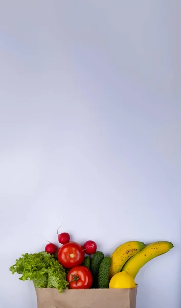 white background with space to insert text with a paper bag for products with vegetables. High quality photo