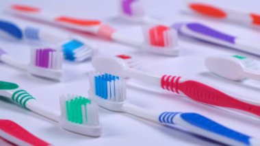 background dental toothbrushes of different colors on a white background top view. High quality 4k footage