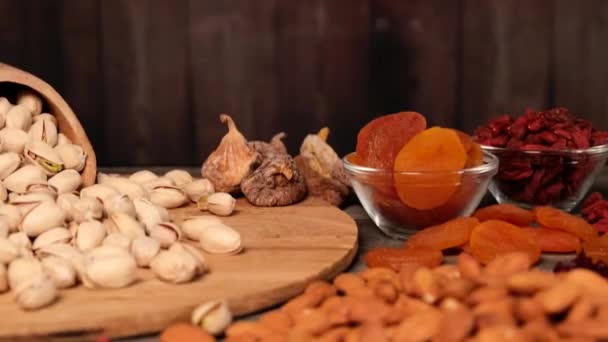 乾燥フルーツとナッツ乾燥アプリコット ピスタチオ アーモンドと生姜のクローズアップ木製の背景に — ストック動画