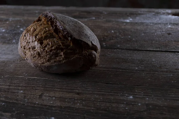 Ahşap arka planda taze siyah ekmek. Gösterişsiz yaşam konsepti geleneksel fırın. Kırsal kesim. Yüksek kalite fotoğraf
