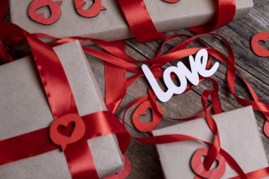 Sevgililer Günü arkaplanı kutular, hediyeler, kırmızı kurdeleler ve tahta bir arka planda kalplerle dolu. Yüksek kalite 4k görüntü
