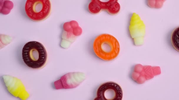 Περιστρεφόμενο Φόντο Από Διάφορα Γλυκά Ζελέ Αρκούδες Ντόνατς Καραμέλες Ροζ — Αρχείο Βίντεο
