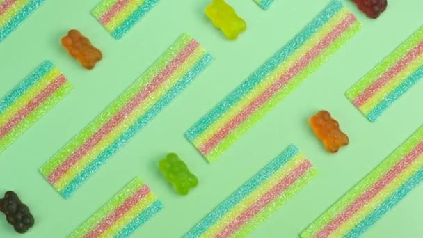 Drehbarer Hintergrund Verschiedener Gelee Bonbons Bären Auf Grünem Hintergrund Nahaufnahme — Stockvideo