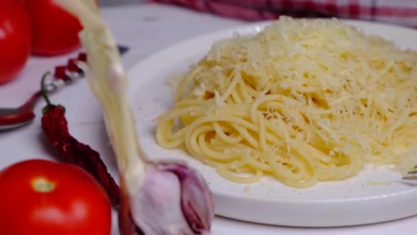 白盘上有意大利面和奶酪 白盘上有西红柿和大蒜配料 西红柿和大蒜配料 高质量的4K镜头 — 图库视频影像