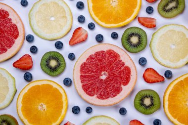 Beyaz arka planda yabanmersini, çilek, limon, portakal, greyfurt ve kivi dilimleri. Sağlıklı beslenme kavramı. Yaz aylarında meyveler, gıda tasarımı. 