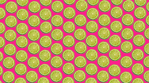 Pembe arka planda olgun kireç dilimlerinin renkli deseni