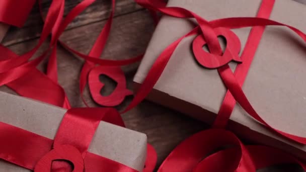 ボックス ギフト 赤いリボンと木製の背景に心を持つバレンタインデーの背景を回転させます 高品質4K映像 — ストック動画