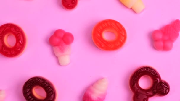 Φόντο Από Διάφορα Γλυκά Ζελέ Αρκούδες Ντόνατς Καραμέλες Ροζ Φόντο — Αρχείο Βίντεο