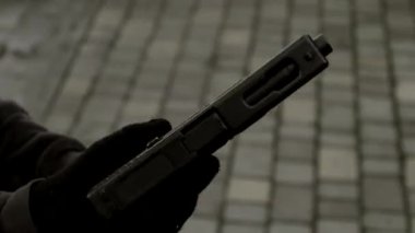 Eldivenli, elinde silah ya da tabanca olan bir adamın siyah beyaz video görüntüleri. Haydut, suçlu, hırsız, hırsız. Yüksek kalite 4k görüntü
